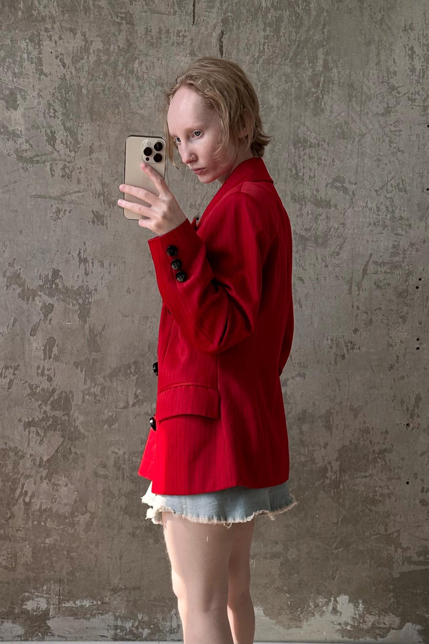 a woman in a red jacket is holding a cell phone