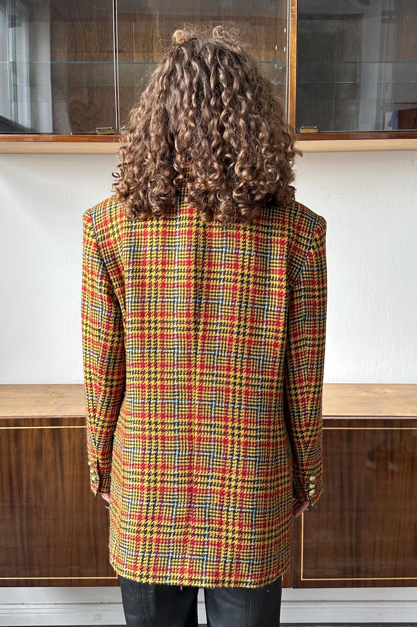 the back of a person wearing a colorful, plaid jacket.
