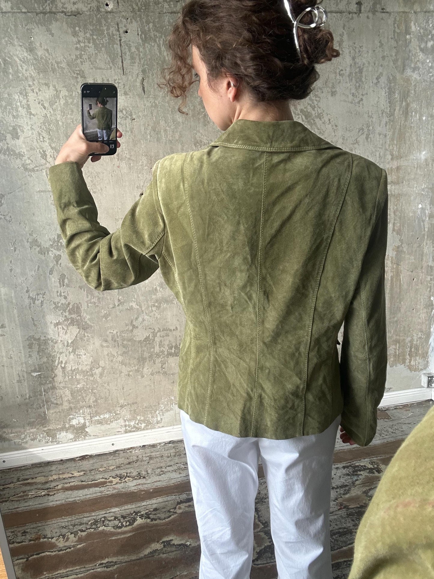 A person is taking a selfie with a smartphone, holding the device up to their face to capture the image.