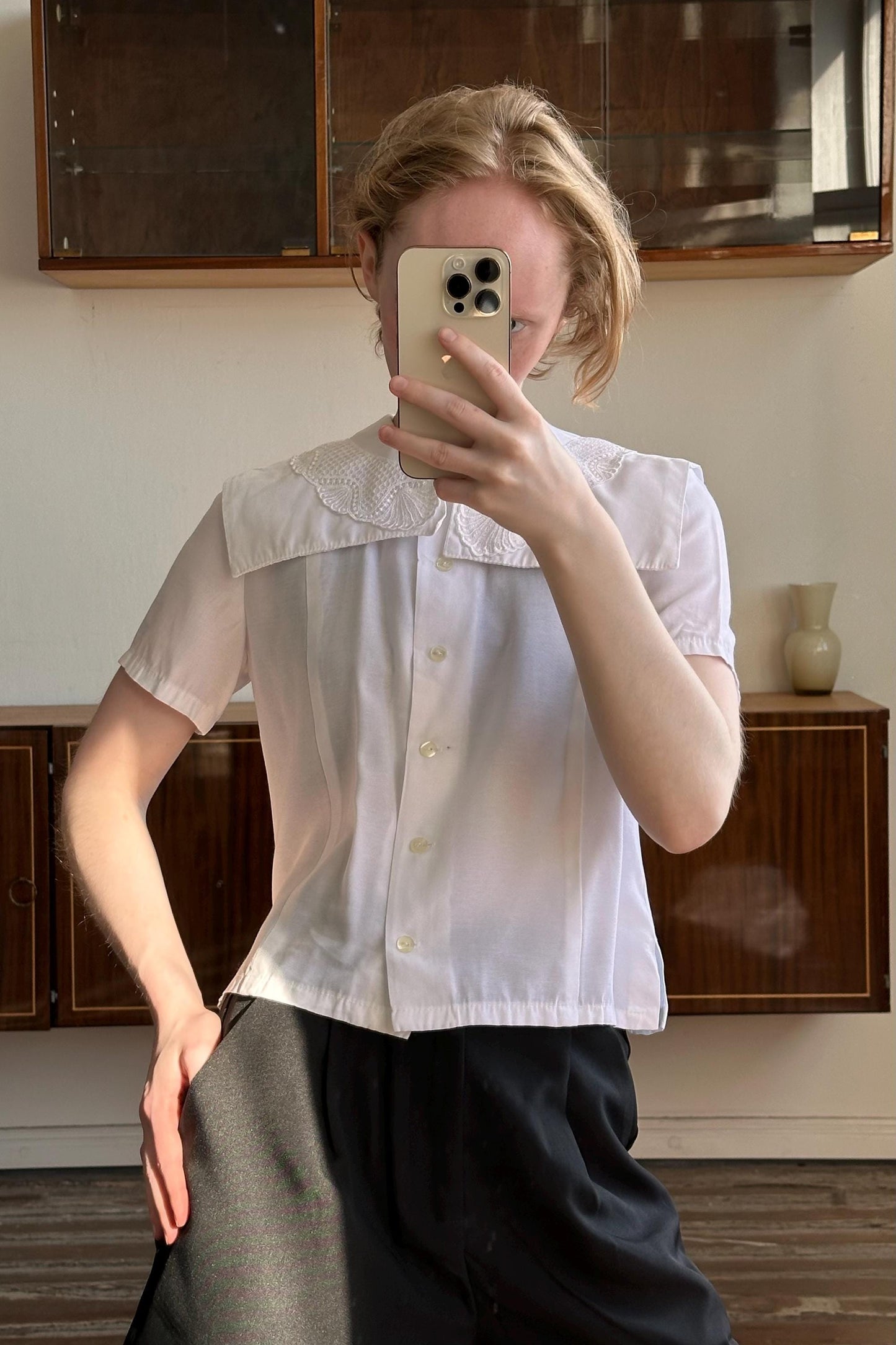 A person is taking a selfie with a smartphone, holding the phone up to their face and covering their face.