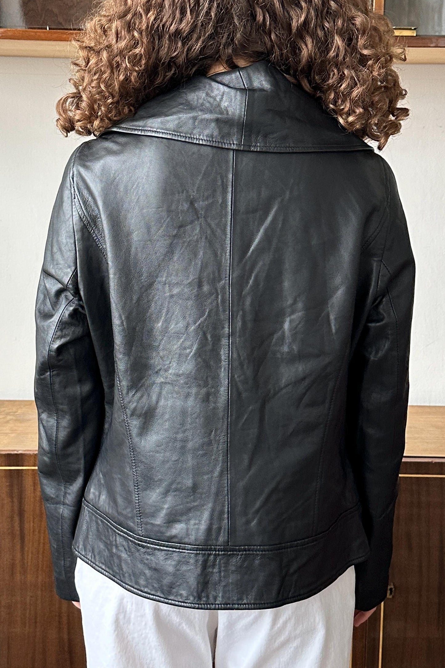 the back view of a person wearing a black leather jacket.
