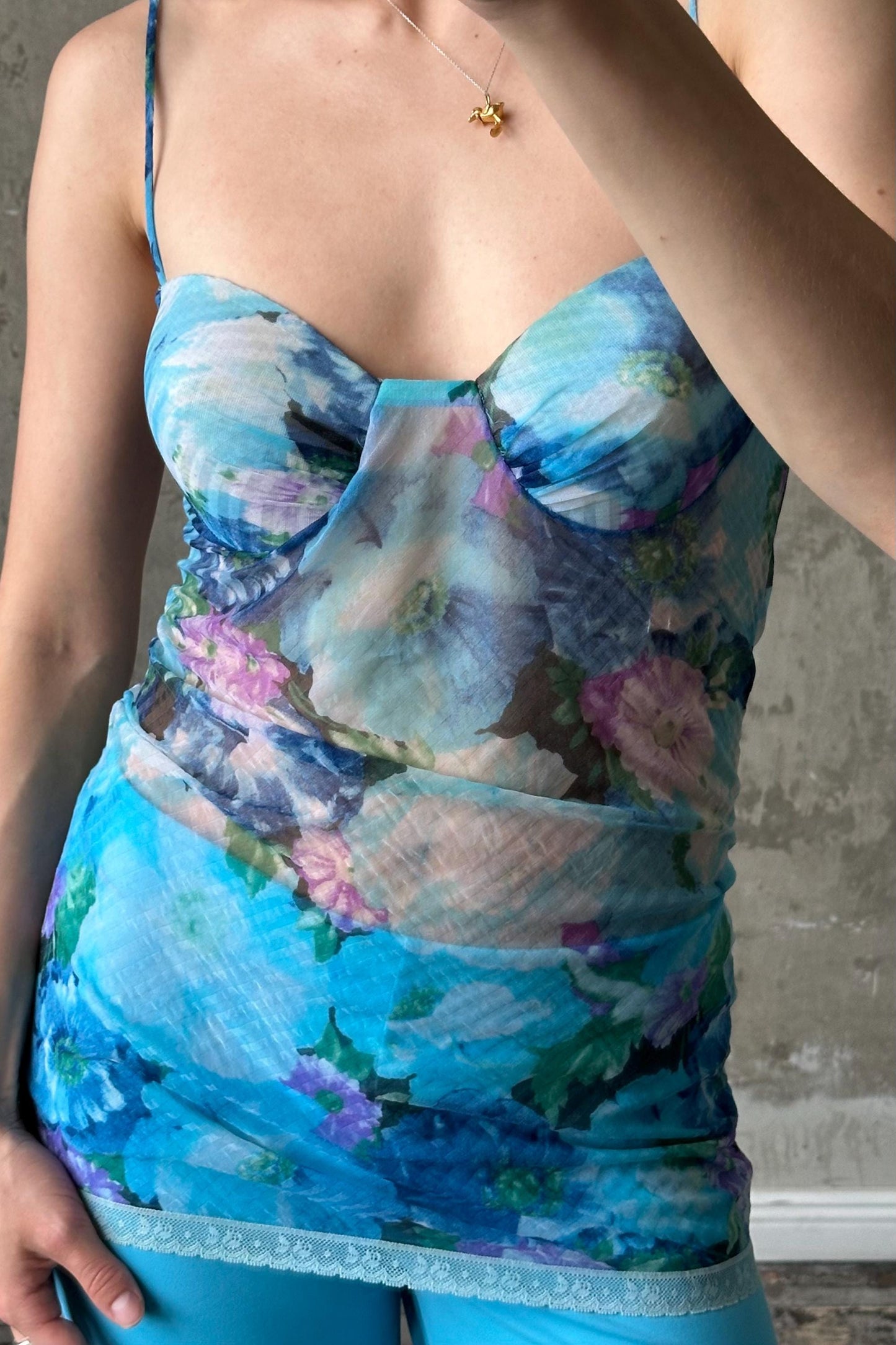 A woman wearing a blue floral print dress with a lace trim.
