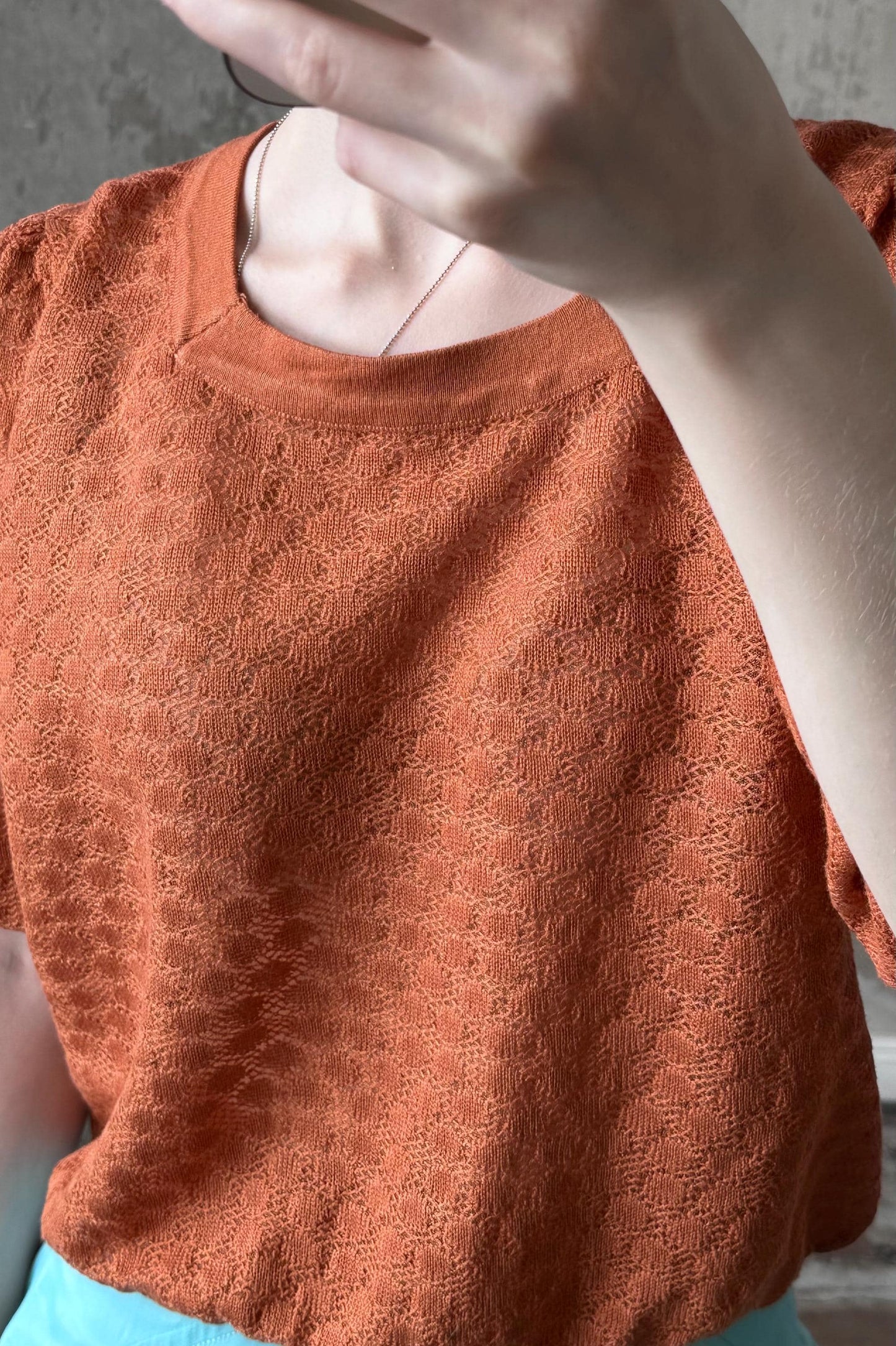 a close-up view of a person's torso wearing a red patterned shirt.