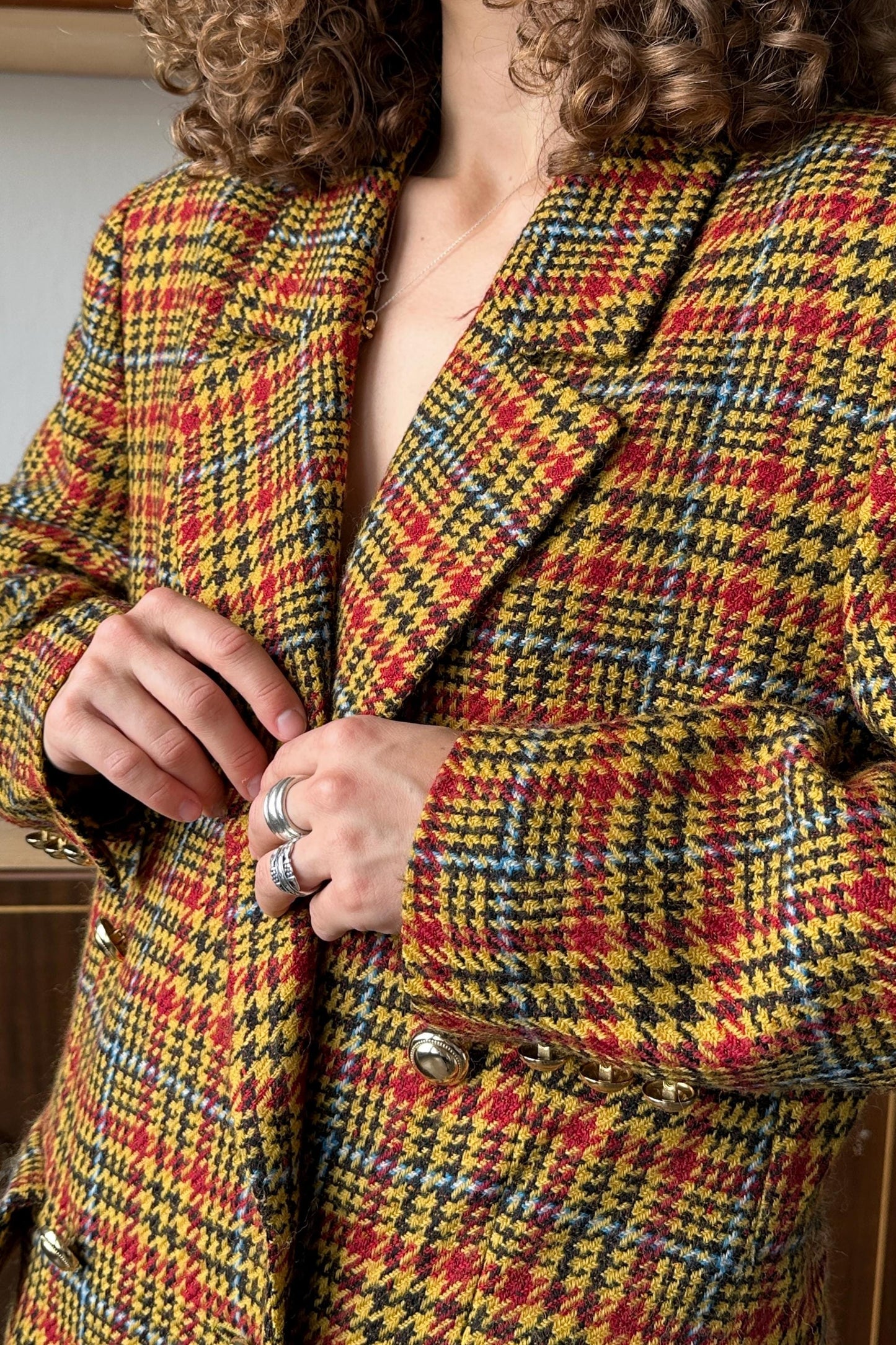 A person wearing a colorful, patterned jacket with a plaid design.