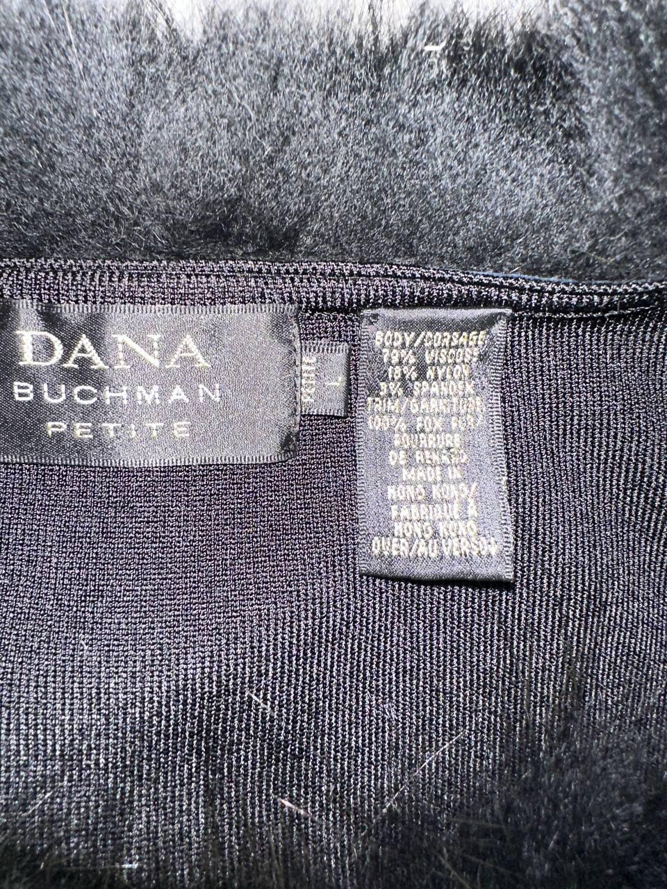 a close-up view of a black fabric, possibly a piece of clothing or textile, with a label attached to it. The label appears to be a description or information about the fabric, possibly related to its material, quality, or origin.