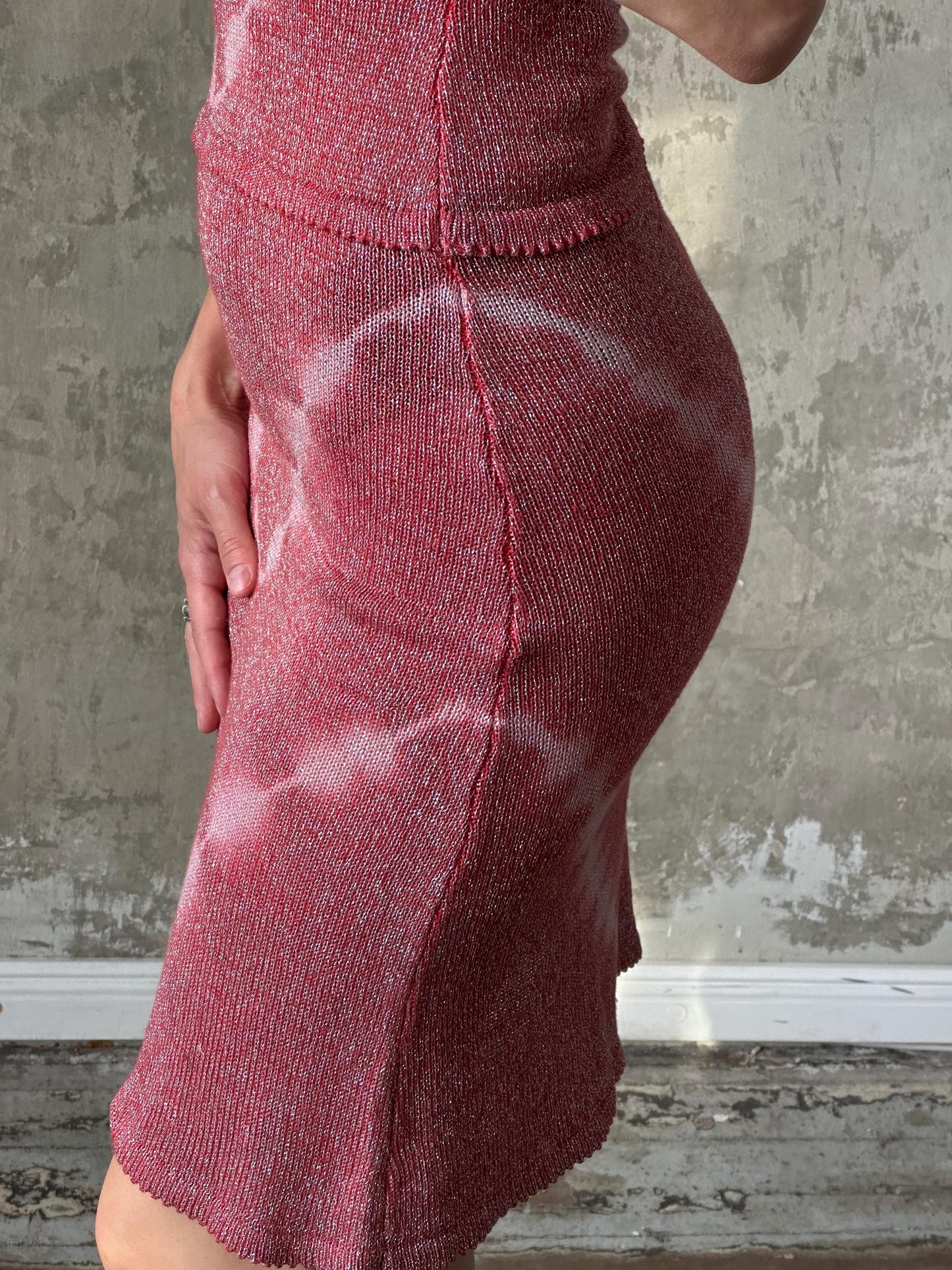 A close-up image of a person wearing a red, sparkly dress.