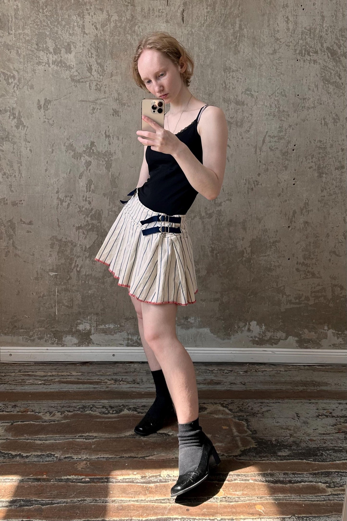 a woman in a skirt looking at her cell phone