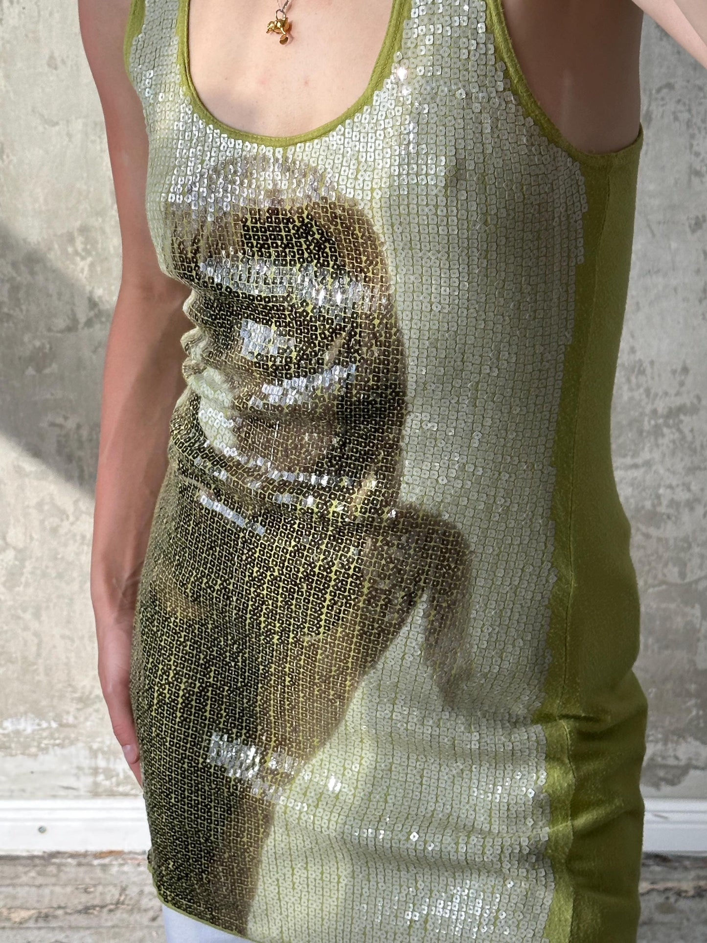 A woman wearing a green sequined dress with a patterned design.