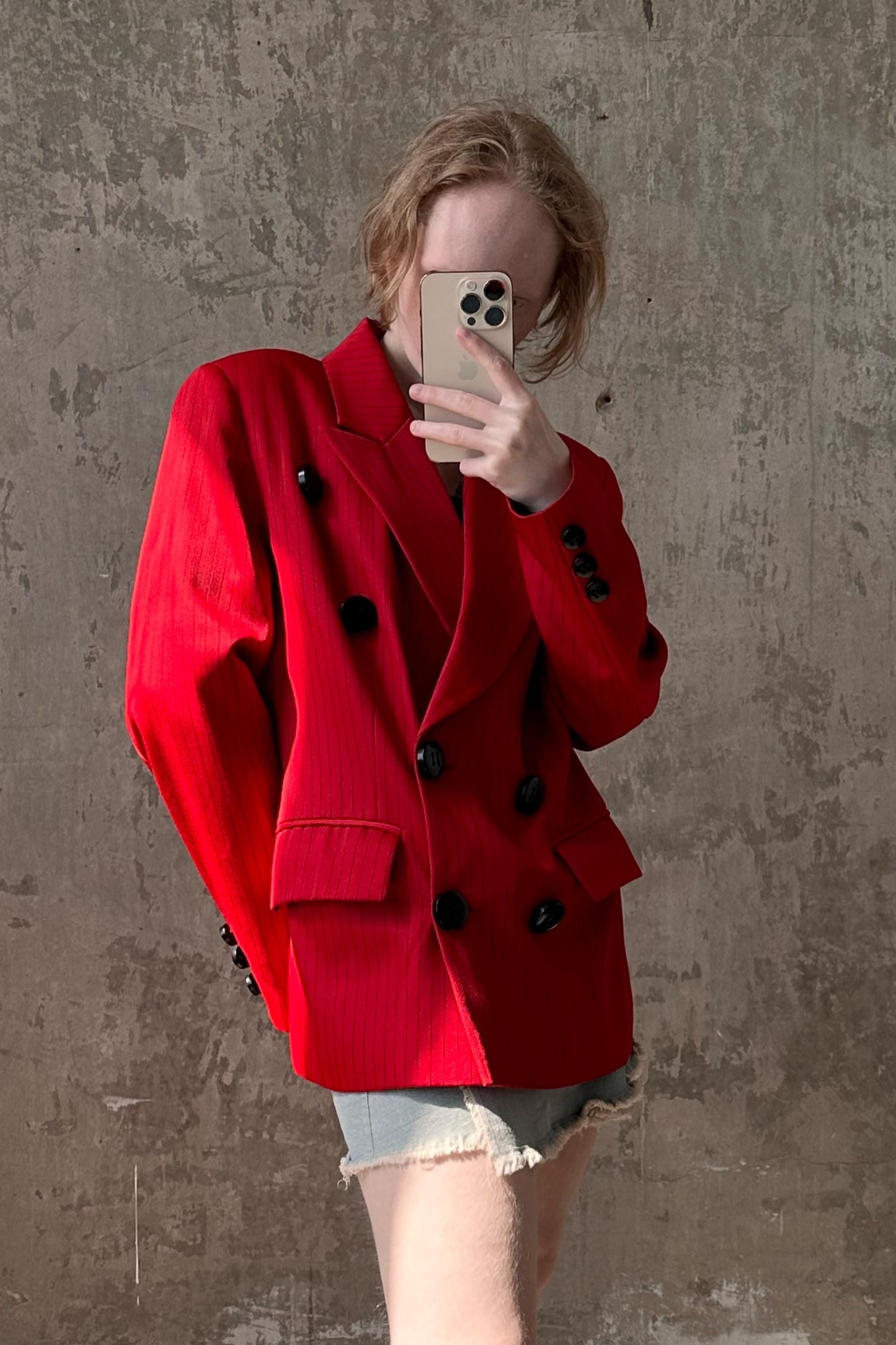 a woman in a red jacket taking a selfie