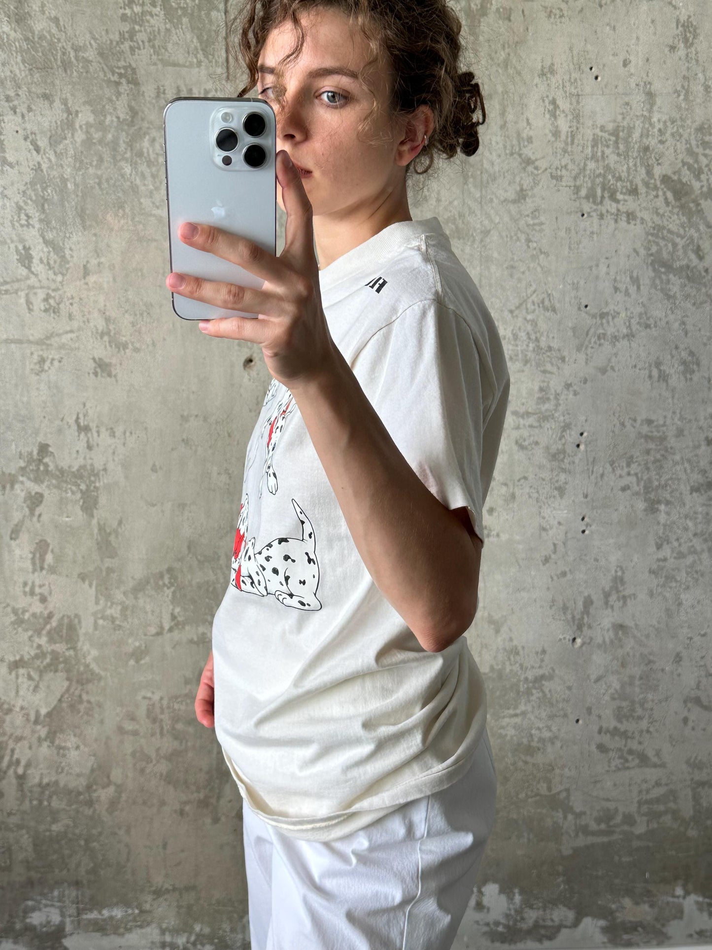 A person is taking a selfie with a smartphone, holding it up to their face and looking at the camera.