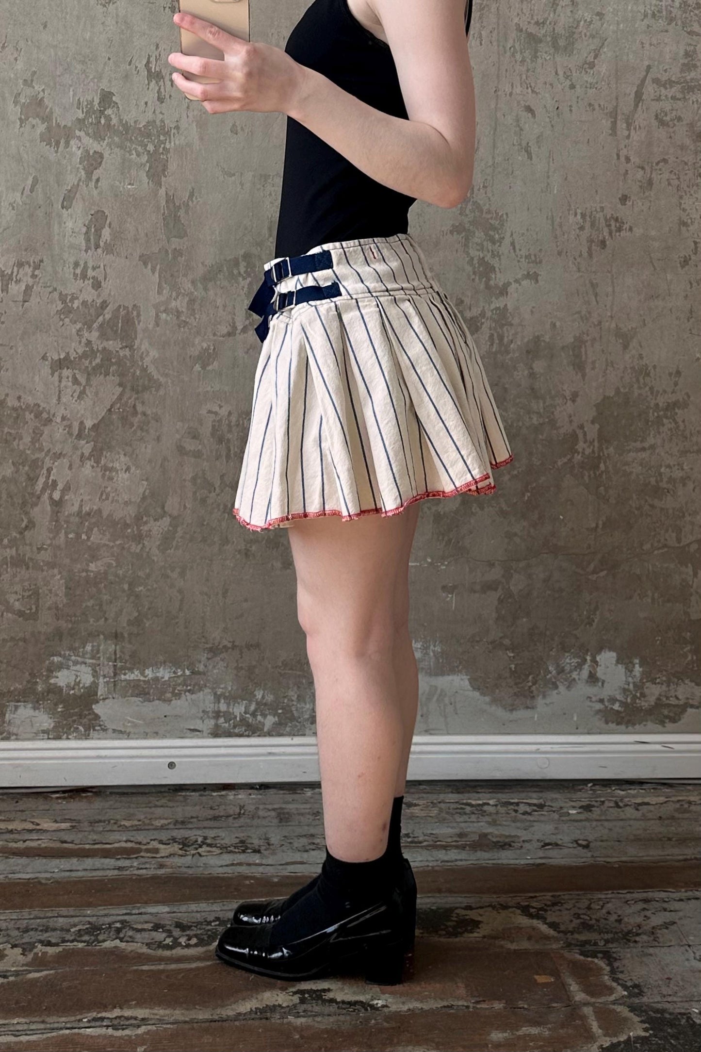 a woman in a skirt holding a cell phone