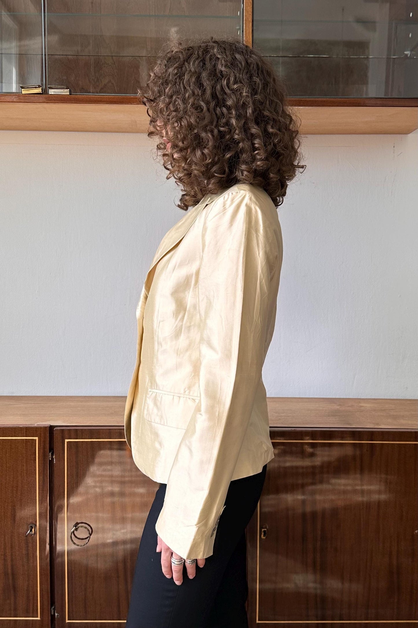 a woman standing in front of a wooden cabinet