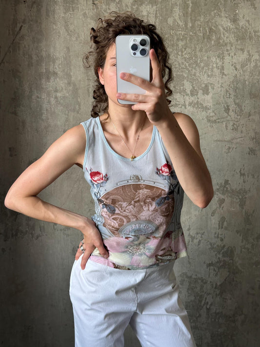 A woman is taking a selfie with her iPhone, holding it up to her face against a concrete wall.