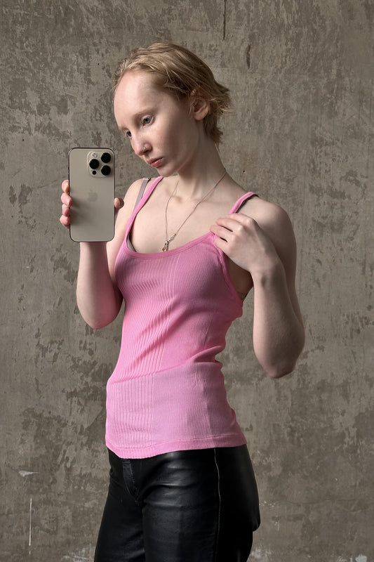 a woman in a pink shirt holding a cell phone