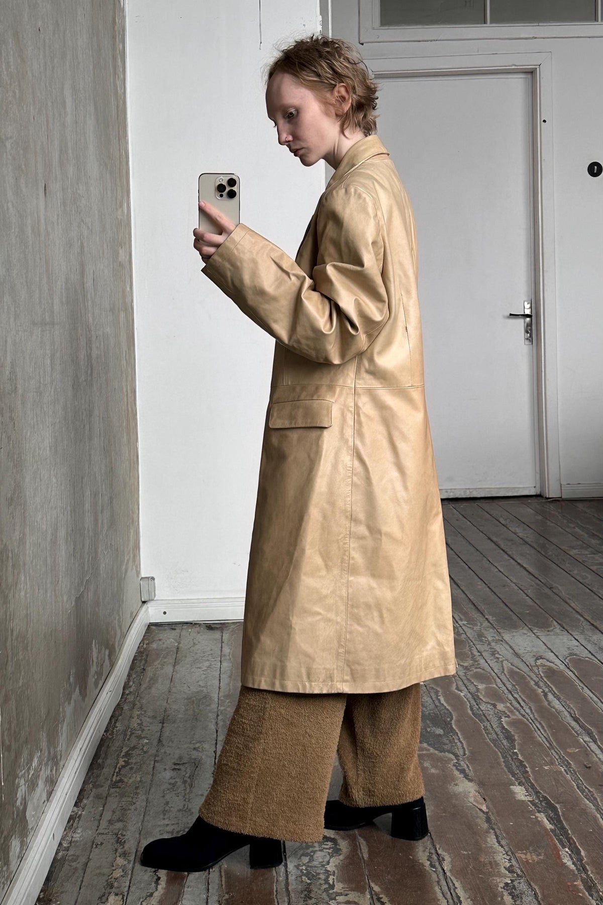 a woman standing in a room looking at her cell phone