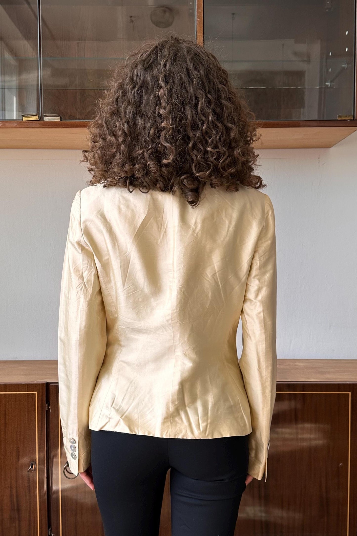 a woman standing in front of a wooden cabinet