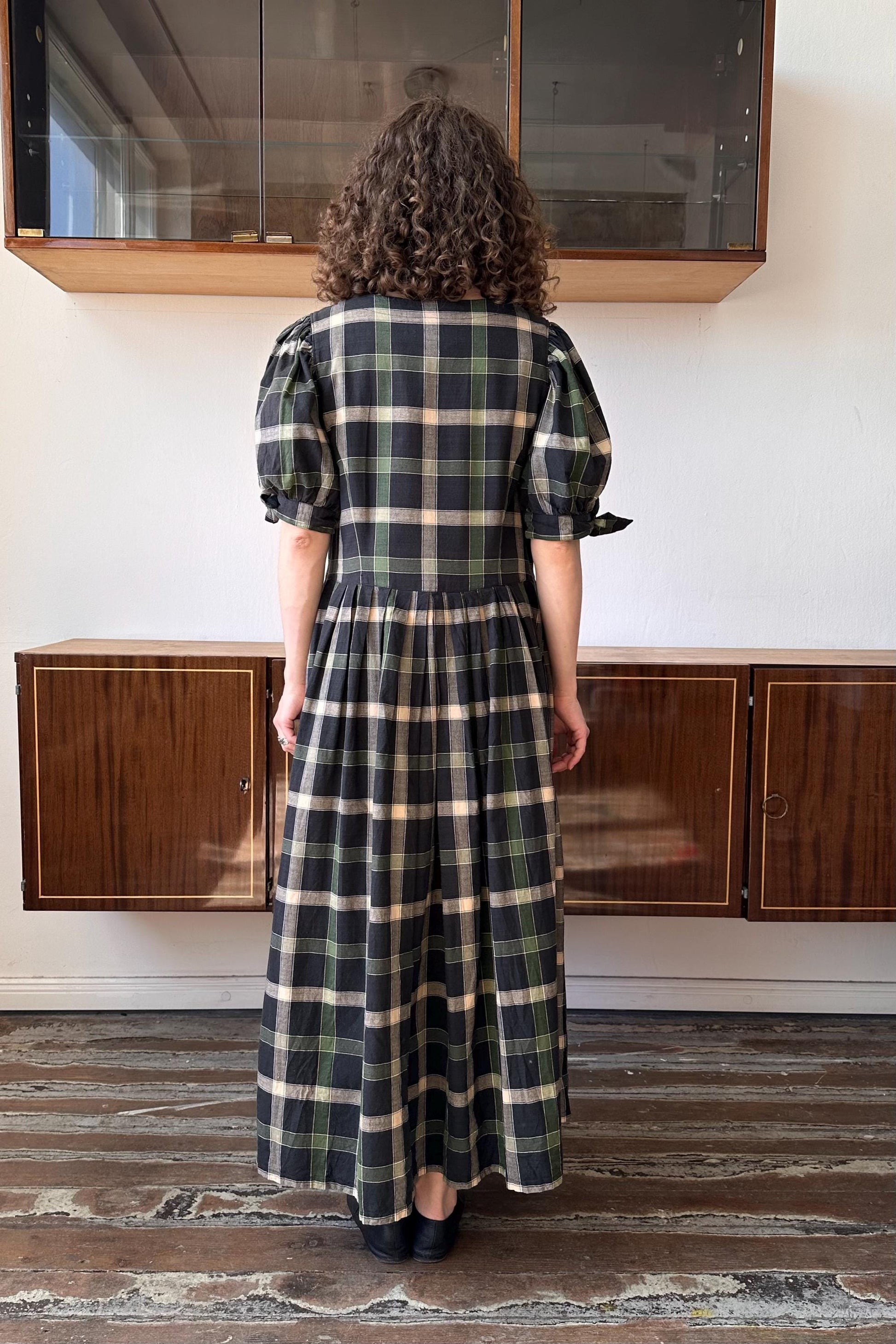 a woman standing in front of a cabinet