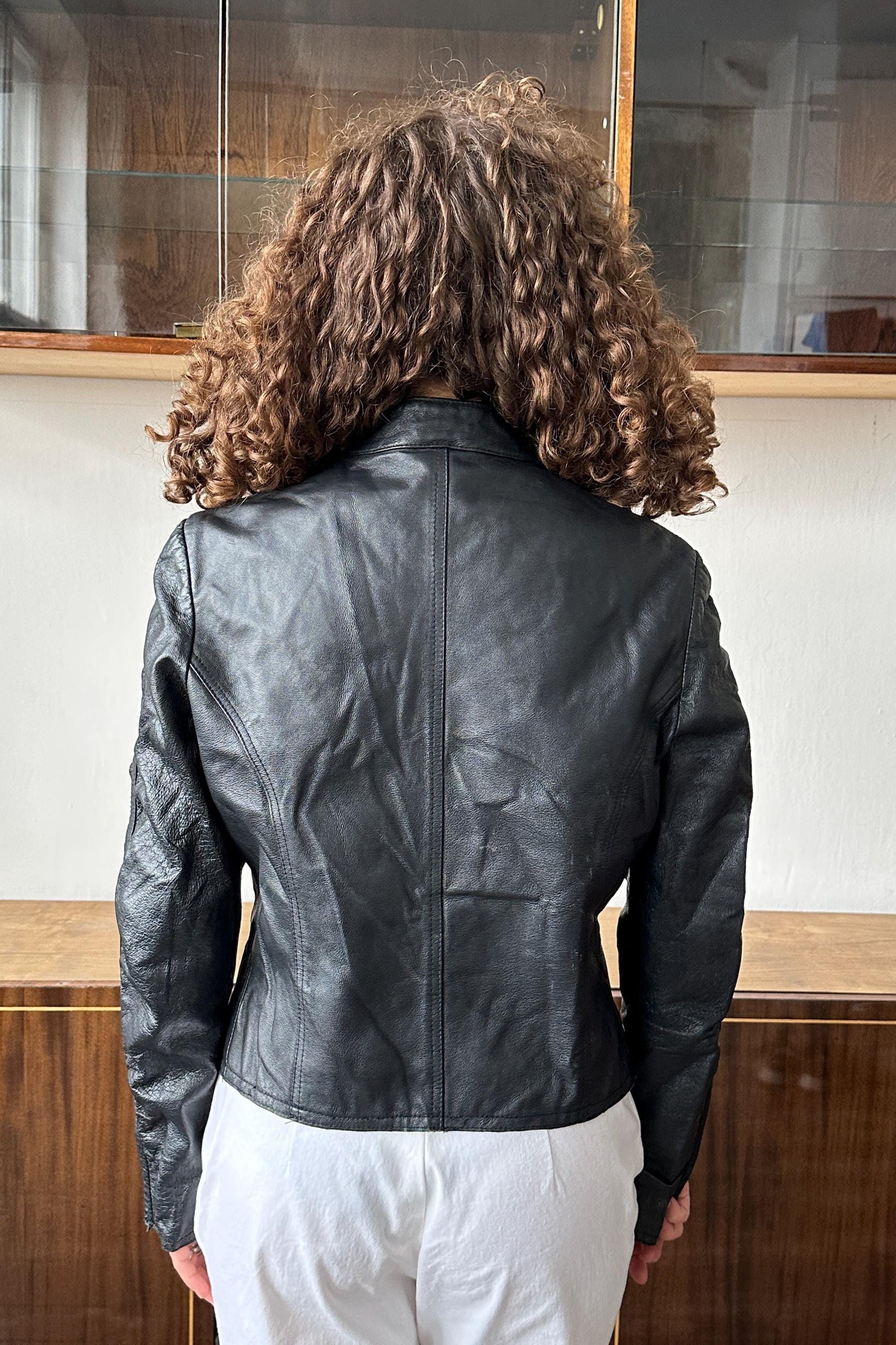 the back of a person wearing a black leather jacket.