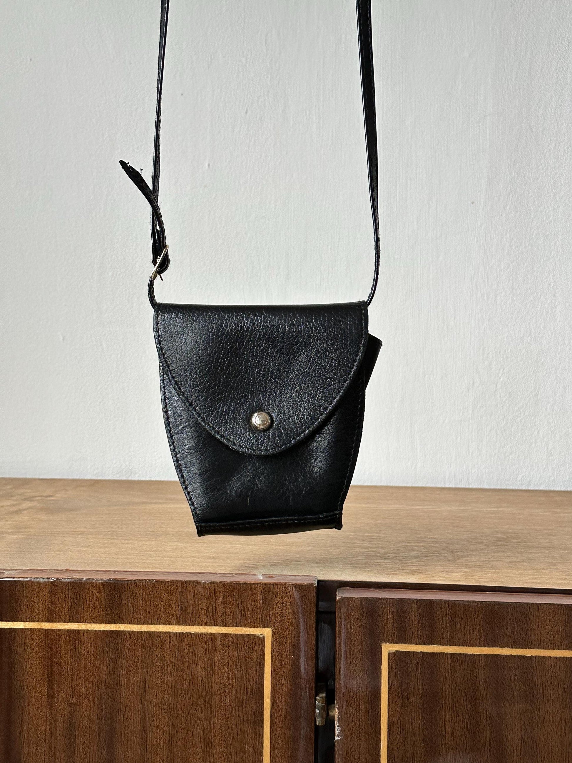 a black purse sitting on top of a wooden cabinet