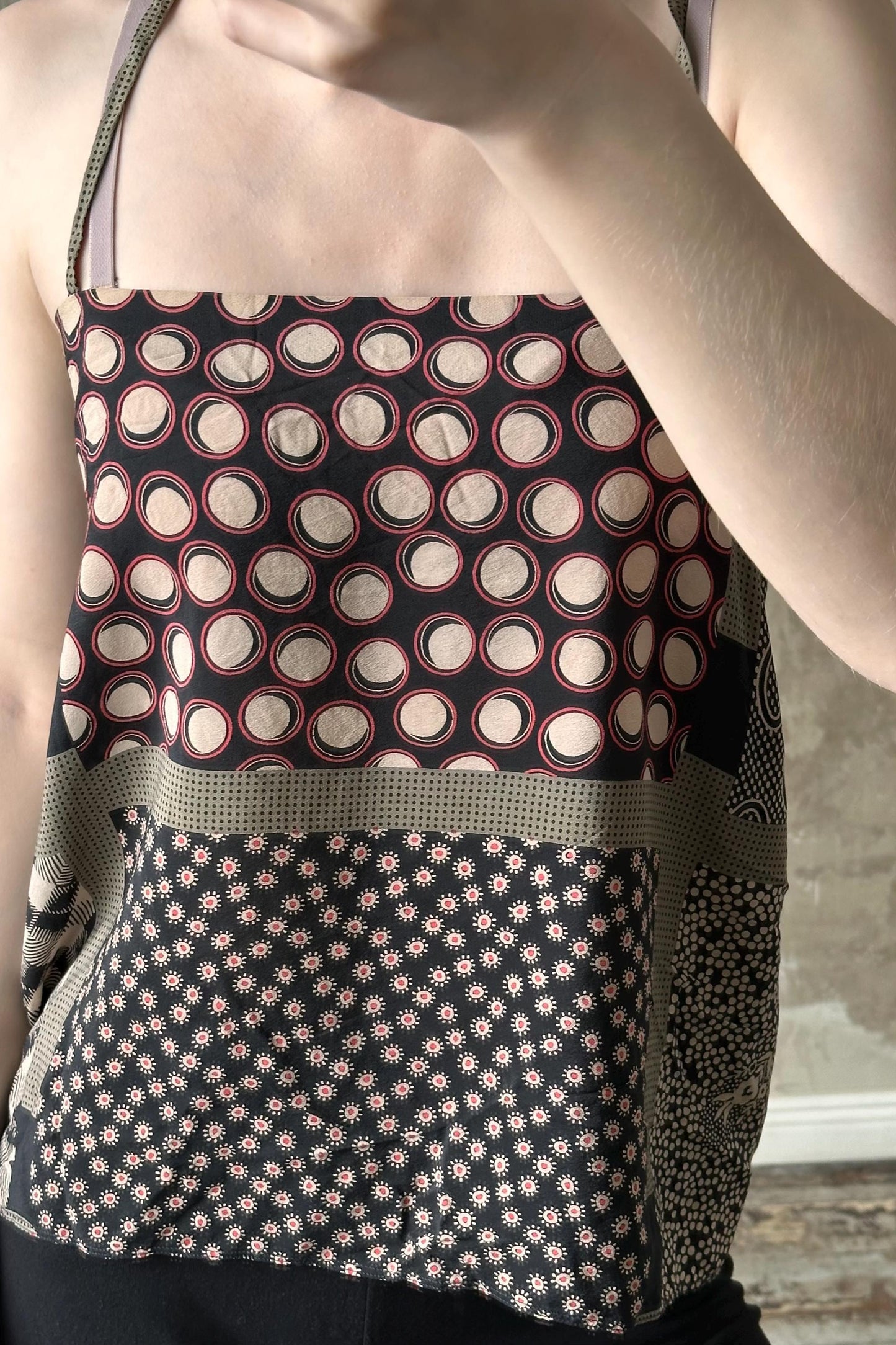 A person is wearing a black and white patterned top with a floral design.