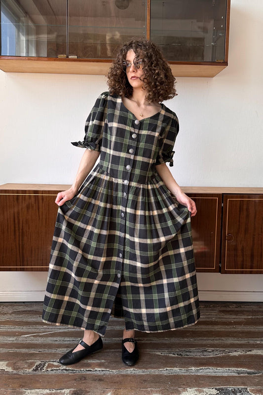 a woman standing in a room wearing a dress