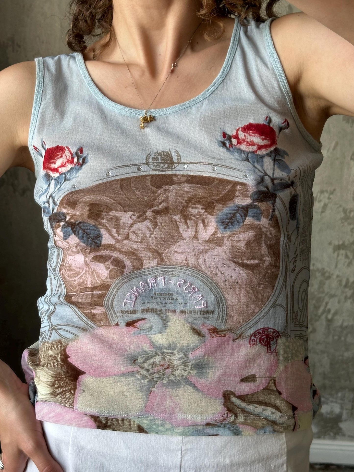 A woman wearing a tank top with a floral print design.