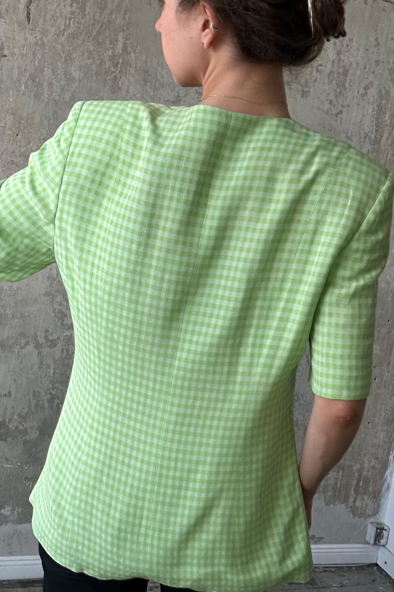 the back of a person wearing a green and white checkered blazer.