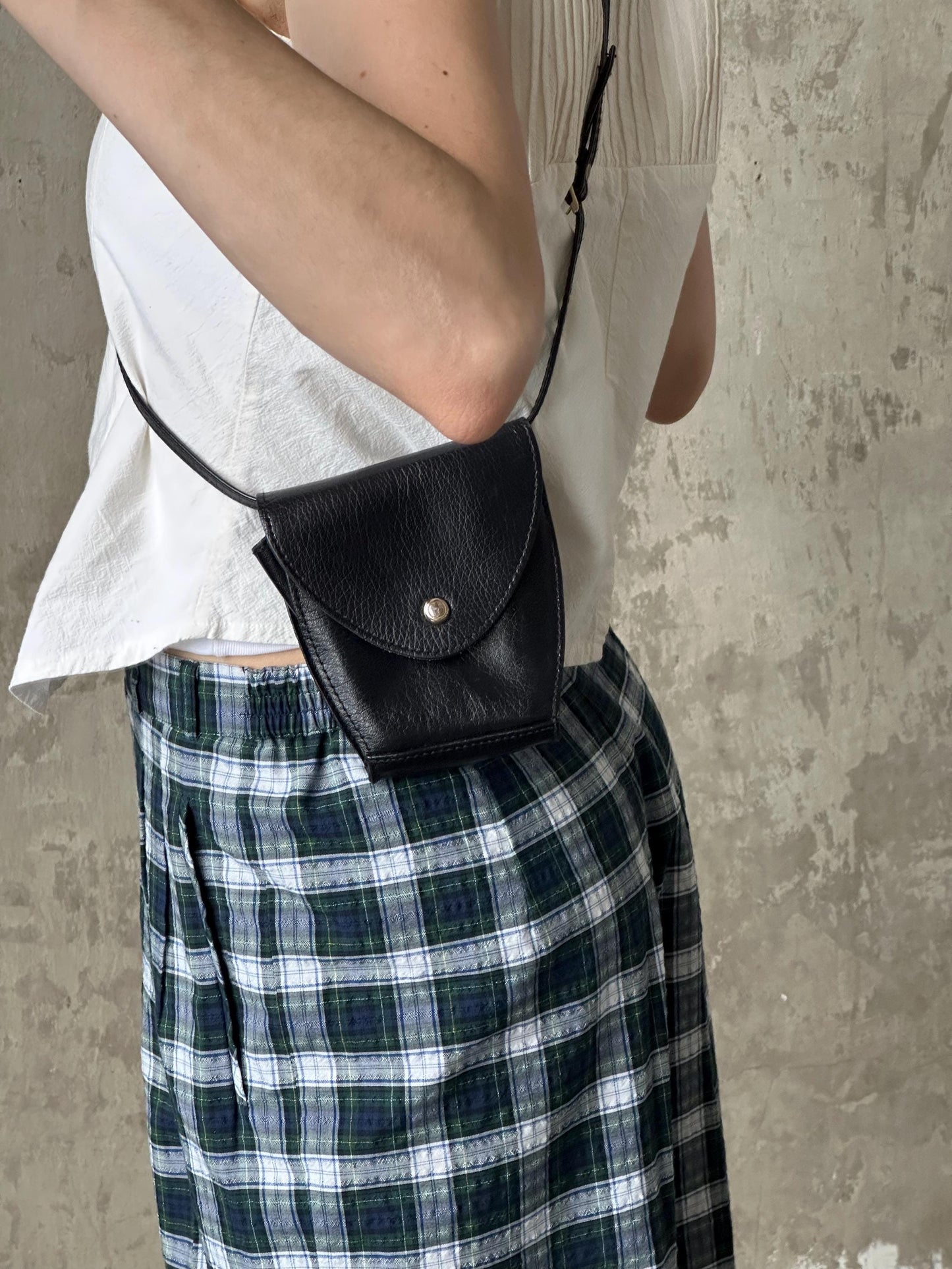a woman wearing a white shirt holding a black purse