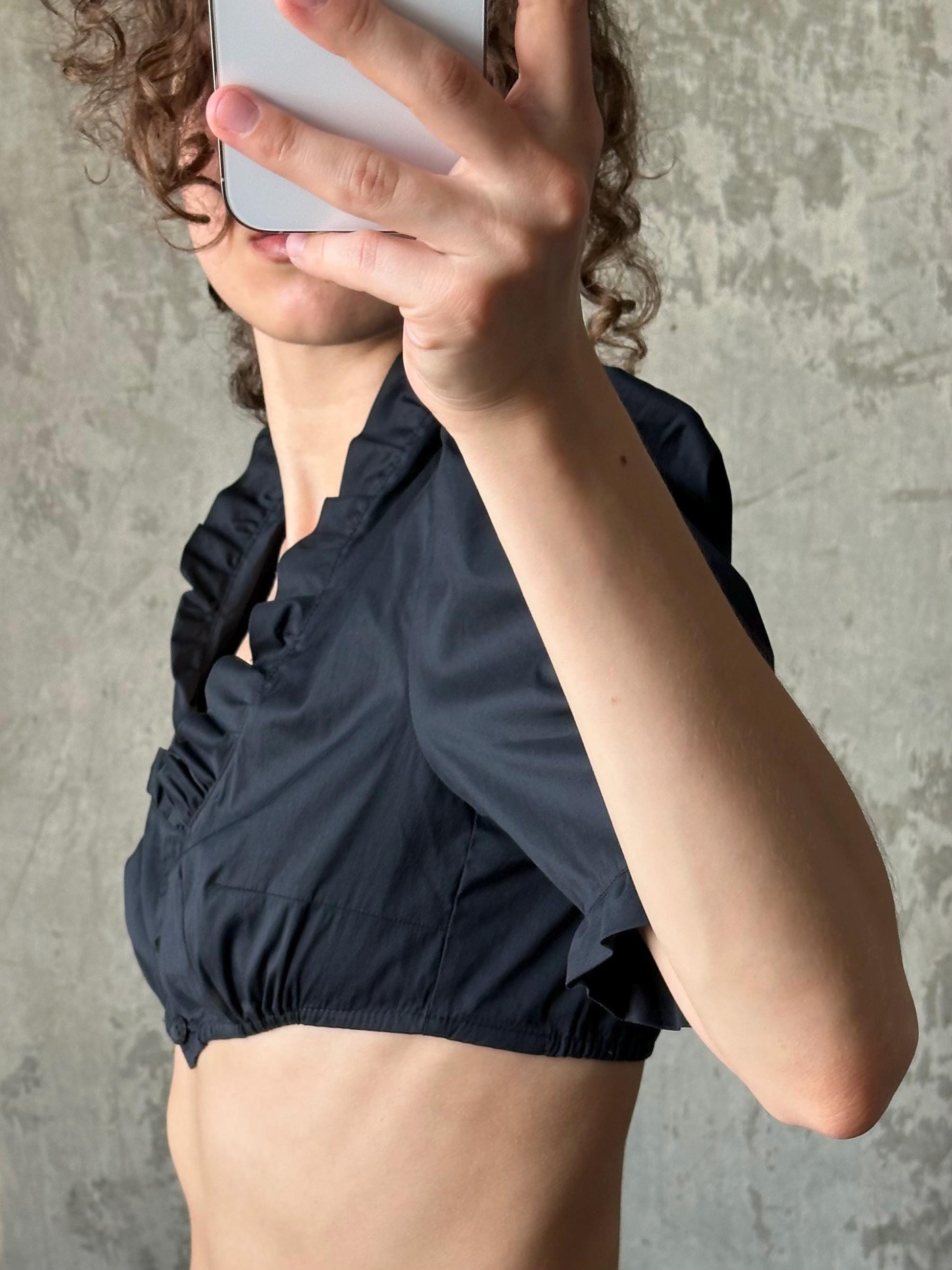 A person is taking a selfie with a smartphone, holding the device up to their face to capture their image.
