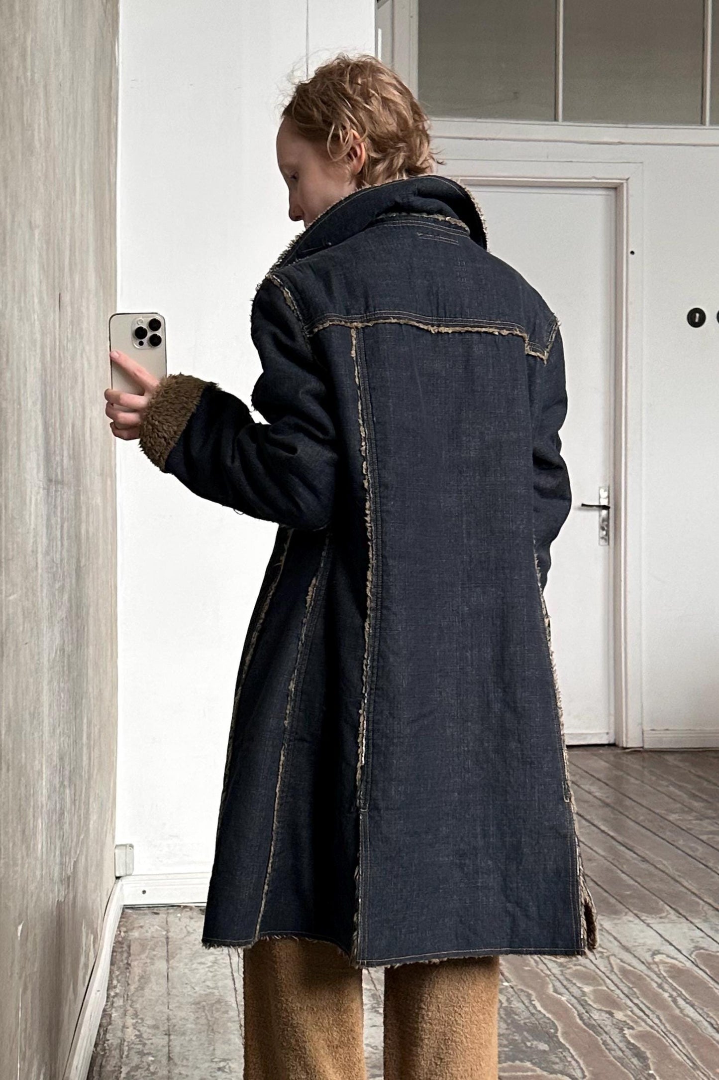 a person standing in a room holding a cell phone