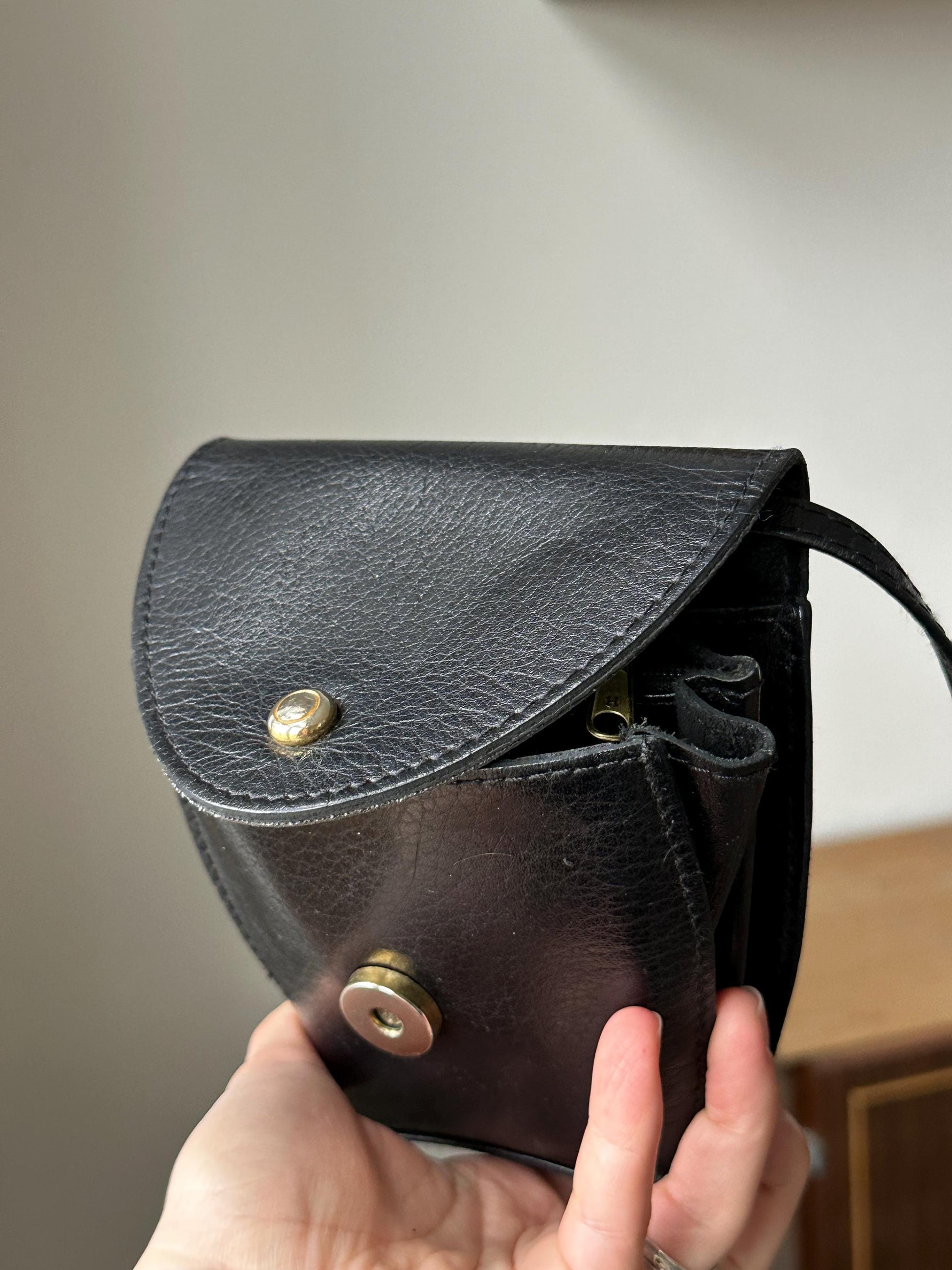 a person holding a black purse in their hand