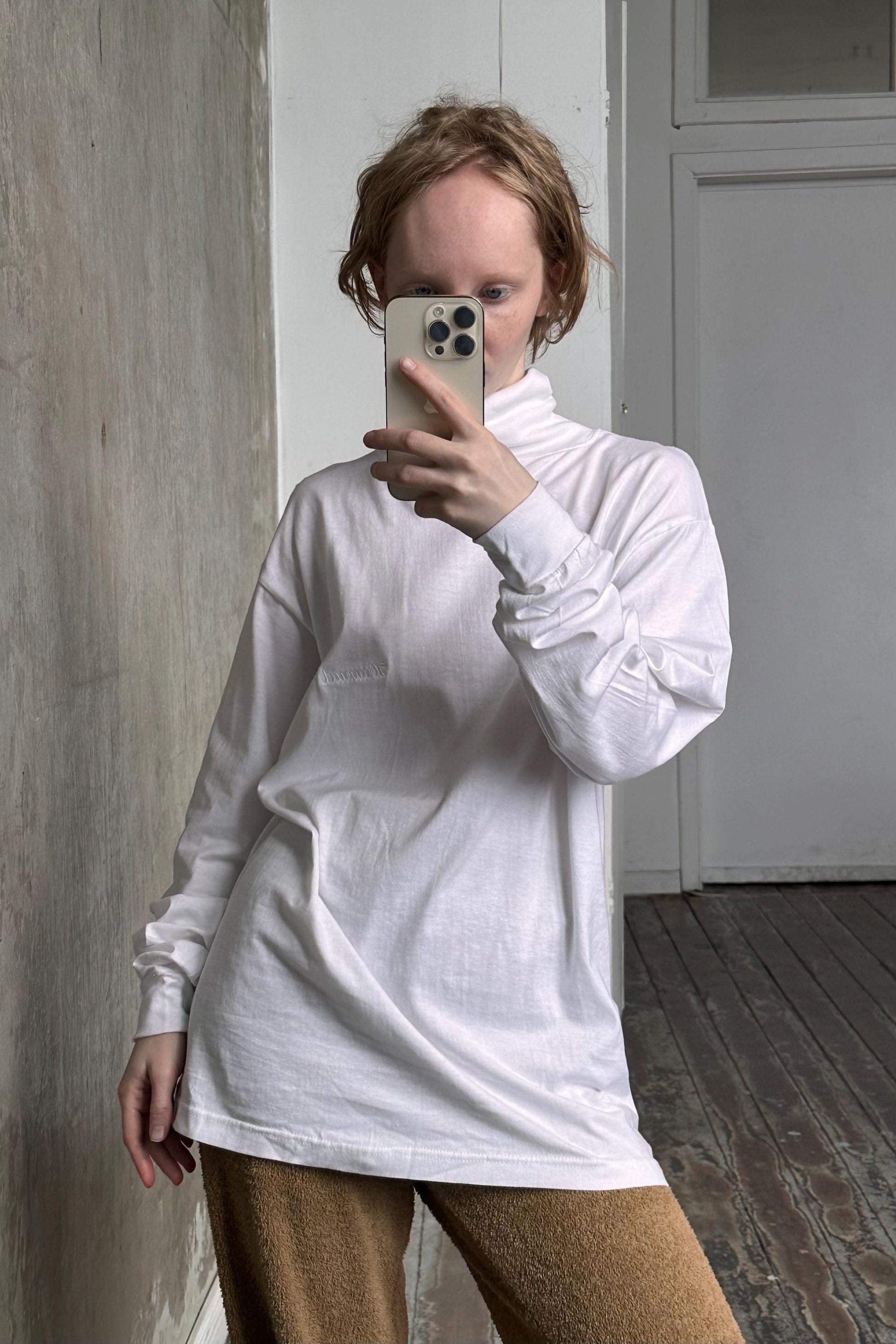 a woman taking a picture of herself in a mirror