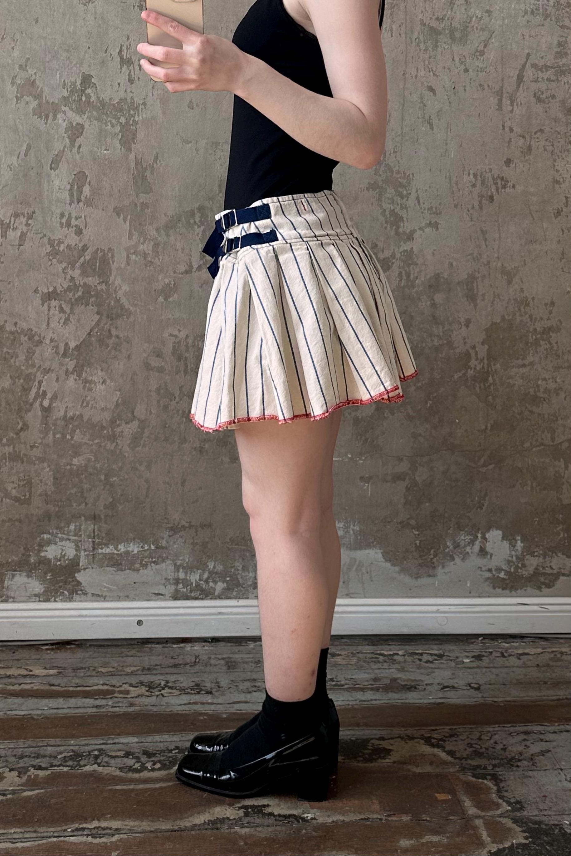 a woman in a skirt holding a cell phone